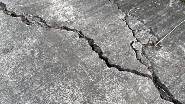 Deep Cracks on Asphalt Road Surface Close Up