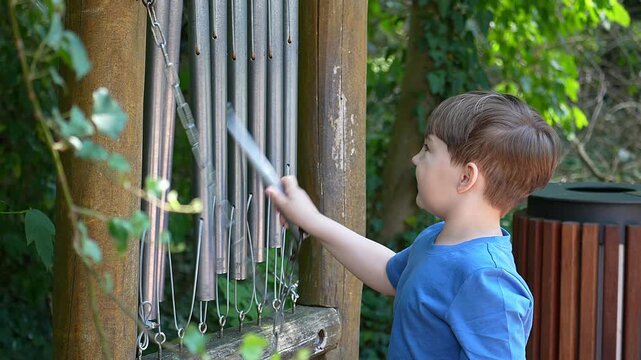 Boy playing outdoor musical instruments in the park