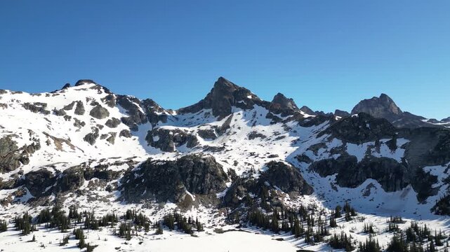 Panoramic aerial video captures the vast winter wilderness of Valhalla Provincial Park with the frozen Gwillim Lake.