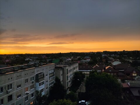 Aerial view of residential neighborhood at sunset with dramatic orange sky