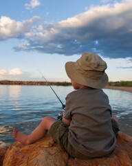 Fototapeta premium Young Boy Joyfully Casting His Line from Tranquil Harbor at Sunset, Embracing the Peace of Nature