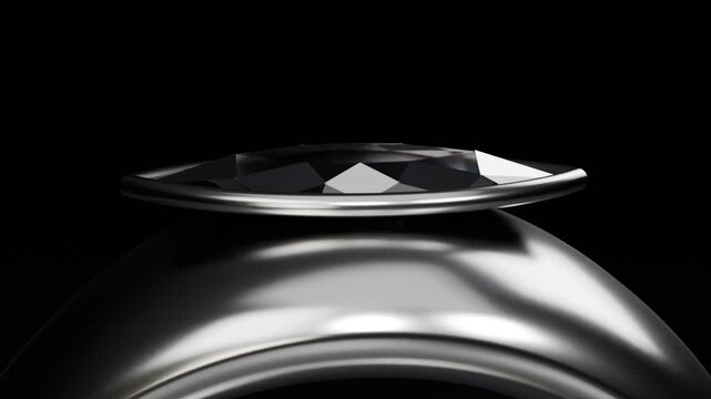 Pulling back camera revealing metal ring on black plinth, showing faceted top, thin bezel