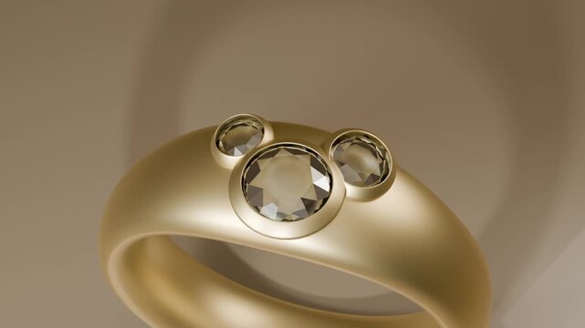 Pulling camera back revealing rotating gold ring with three bezel gems on beige table, soft light