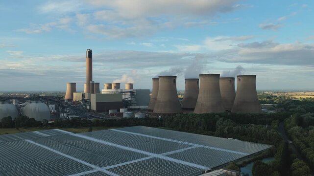 Industrial Power Plant and Extensive Solar Farm Side by Side From Above
