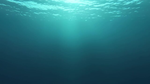 Underwater ocean background with light rays filtering through the deep blue water surface
