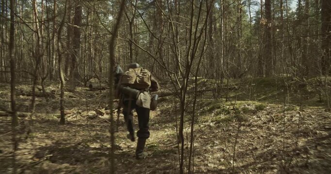 Group Of Soldiers With Carabines Mauser 98k Sneak Carefully Through Forest. Danger Of Sudden Attack. Reenactors Dressed As German Infantry Soldiers Search Ambush In Forest. Wermacht Military Uniform