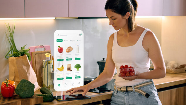 Woman ordering fresh groceries through smart kitchen interface with digital shopping app. Concept of online grocery delivery, smart home technology, meal planning and healthy shopping.