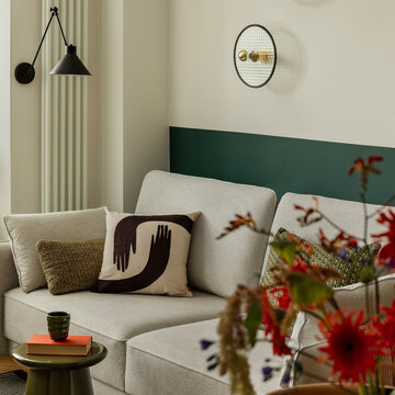 Cozy living room interior with modern sofa, decorative pillows, and elegant light fixtures, creating a stylish and inviting space