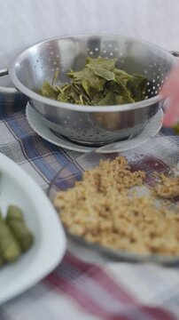 Close-up of making traditional Turkish stuffed grape leaves sarma