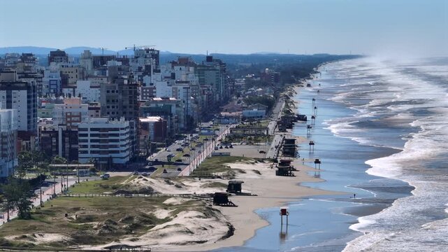 Capao da Canoa beachfront with high-rise buildings and lifeguard towers and aerial view.