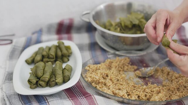 Close-up of making traditional Turkish stuffed grape leaves sarma