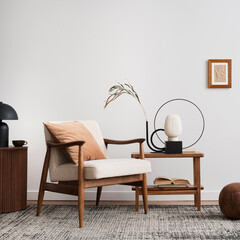 Warm and cozy interior of living room interior with mock up poster, beige armchair, coffee table, lamp, vase with dried flowers and personal accessories. Home decor. Template. © FollowTheFlow