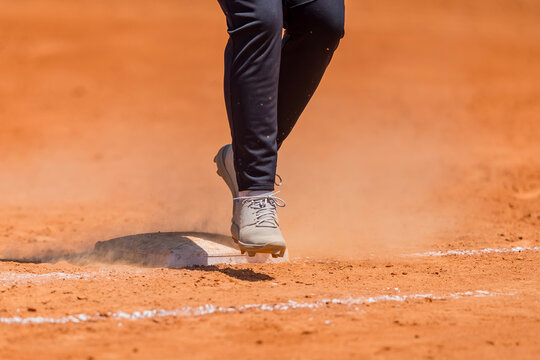 Racing Down the Line: Youth Baseball Player Hustles Toward First Base After a Big Hit
