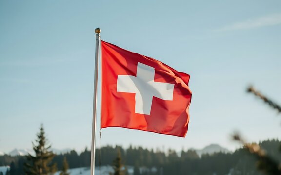 National flag of switzerland waving against blue sky and alps