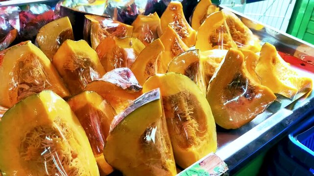 Ahuyama pumpkin zapallo squash slices Cucurbita moschata wrapped in plastic, 4K 60fps.