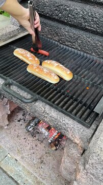 Cuisson de hot-dogs sur un feu de camp pendant les vacances. Saucisses et pains &agrave; hot-dog &agrave; faire cuire.