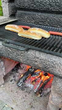 Cuisson de hot-dogs sur un feu de camp pendant les vacances. Saucisses et pains &agrave; hot-dog &agrave; faire cuire.	
