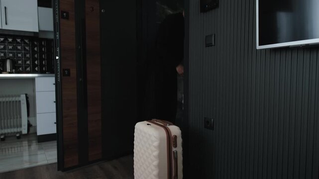 Young man leaving furnished apartment with luggage after temporary stay, housing instability, flexible living, nomadic lifestyle and uncertain future transition concept