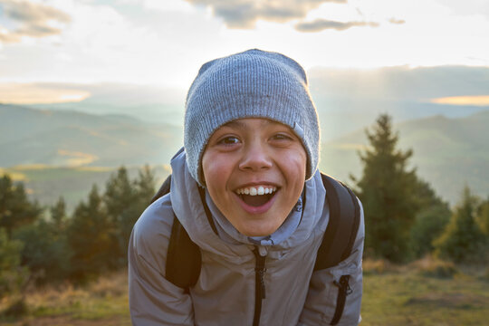 Close up portrait of a happy laughing boy enjoying autumn mounta