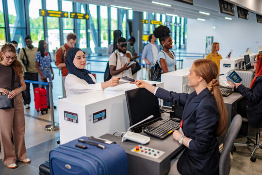 Travelers checking in at airport with diverse group queueing