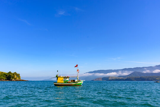 Fishing trawler at sea between the mountains of the north coast of Sao Paulo in Ilhabela.