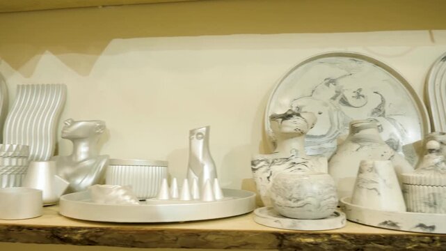Collection elegant silver metallic sculptural busts textured white marble patterned ceramic plates and minimalist plaster vases