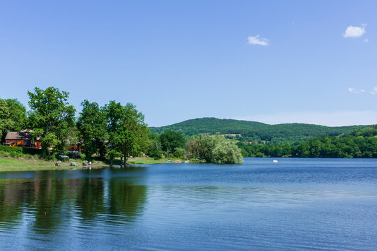 Lake surrounded by forest in summer, Lac de Panneciere, Panneciere Lake in Morvan Regional Nature Park, Nievre department, France