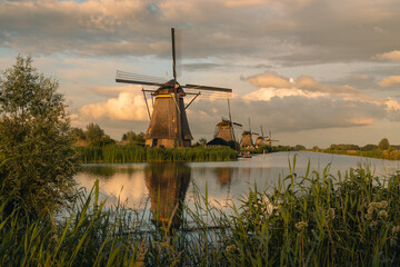 Kinderdijk windmills reflecting in a canal at sunset, representing Dutch heritage and sustainable energy © Víctor Sánchez