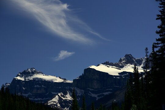 Majestic, snow-capped peaks of Mount Saskatchewan and the Saskatchewan Glacier headwall rising into a deep blue alpine sky along the Icefields Parkway