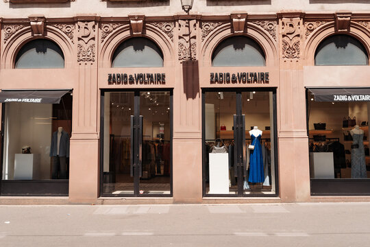 STRASBOURG, FRANCE - JULY 1, 2026 : Exterior of Zadig and Voltaire Fashion Boutique With Window Display and Blue Dress on Historic Facade