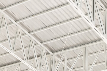 Fototapeta premium Detailed Abstract View of White Metal Roof Structure and Trusses,An abstract, detailed view looking upwards at the underside of a modern, industrial-style roof structure. The image features a complex 