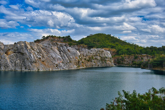 Calm lake in a former quarry surrounded by limestone mountains and forest. Na Fai in Phu Pha Man district, Khon Kaen, northeast Thailand 
