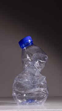 Stop motion animation of a plastic PET bottle compressing and returning to its original shape, demonstrating material elasticity, recyclable packaging and sustainability concept