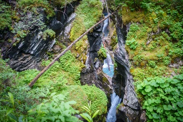 rauschender Wasserfall zwischen Felsen mit altem Baumstamm © by paul