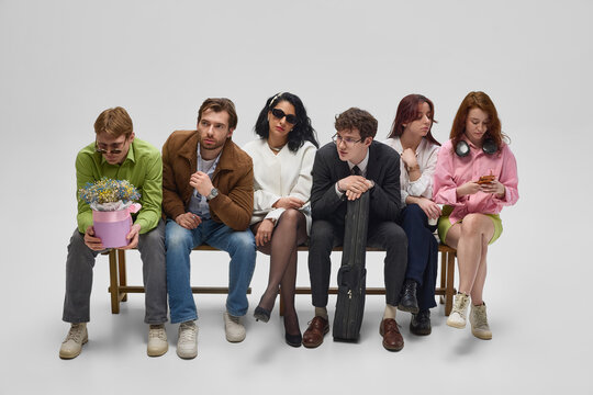 Diverse people standing in queue and interacting on white studio background. Concept of social behavior, public waiting, communication, patience and shared experience.