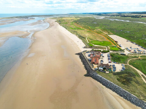 Wonderful aerial view of Brancaster beach in Norfolk, UK seen at low tide. A golf club is on the right seen with boulders used as a costal defence during high and spring tides.