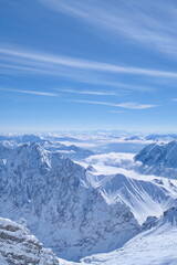 Fototapeta premium Stunning winter panoramic view of alpine mountain ranges above the clouds.
