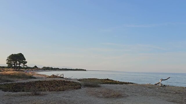 Horizontal panning shot of the calm Mediterranean Sea and Travo beach at sunset, Corsica.