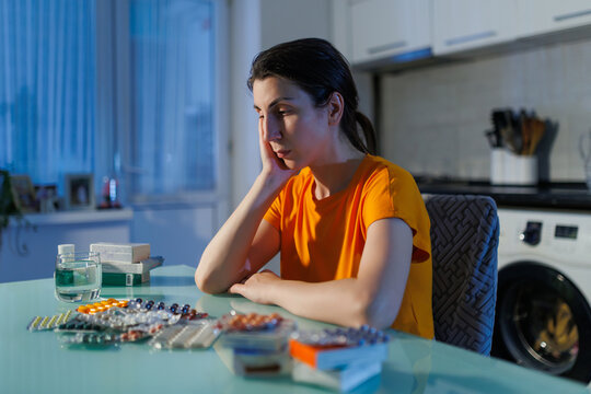 Stressed Woman Struggling With Night Medication Dose At Home Table