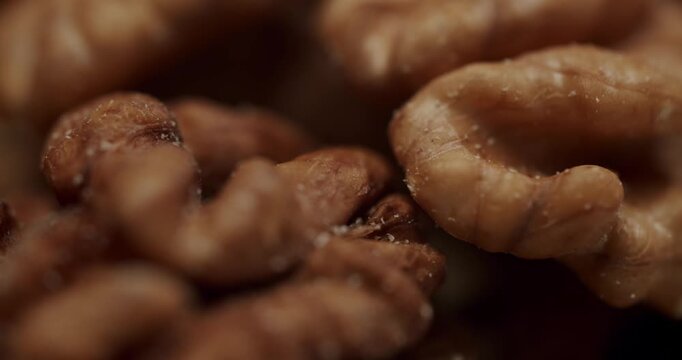 Macro view of a pile of raw, shelled walnuts rotating slowly in a close-up shot, showcasing their texture and detail as a healthy food ingredient rich in omega-3 and antioxidants.