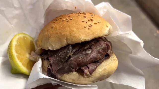 Palermo, Sicily authentic street food called pani ca meusa. A traditional sesame sandwich filled with boiled calf spleen and lungs.Served with a squeeze of fresh lemon juice and a pinch of salt.