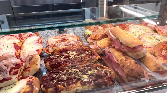 Sicily typical street food window bar counter display with pizzas and traditional authentic panini, Palermo, Sicily, Italy.
