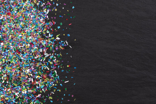 Microplastic on black background with copy space, close up, top view