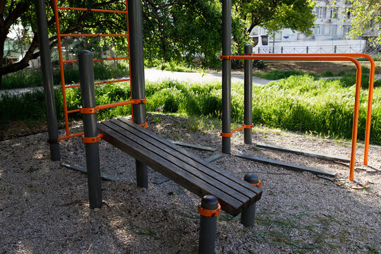 incline sit up bench and parallel bars at public outdoor fitness park showing accessible exercise equipment for strength training concept of fitness wellness recreation and healthy lifestyle