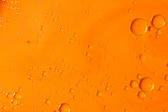 Abstract orange liquid background with floating oil bubbles