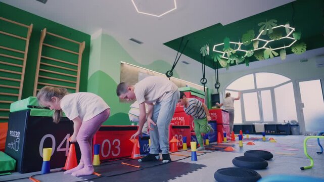 Children participate in various exercises and an obstacle course at a dedicated kids fitness center.