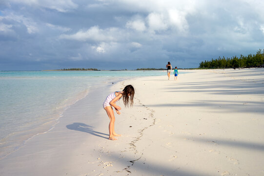 Family on vacation in Bahamas walks together on a beach