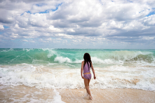 Child playing in the waves on a Bahamas beach