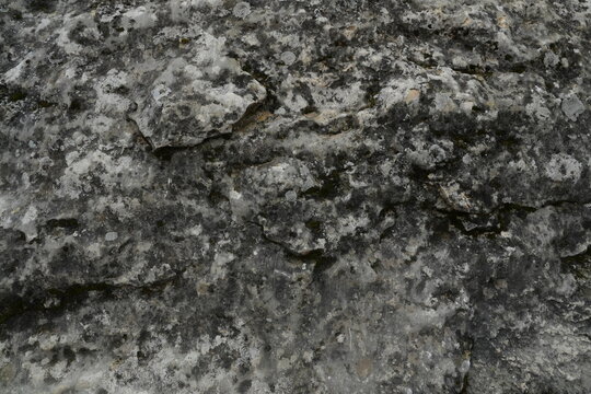 Monochromatic Grey and Black Abstract Rock Texture Background Rough Uneven Surface with Chiaroscuro Lighting Ideal for Copy Space and Naturalistic Backdrops