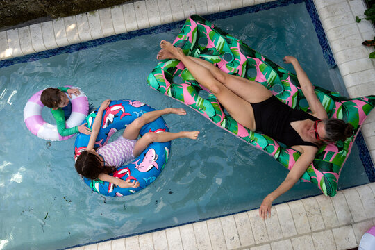 Mom and kids float in pool together